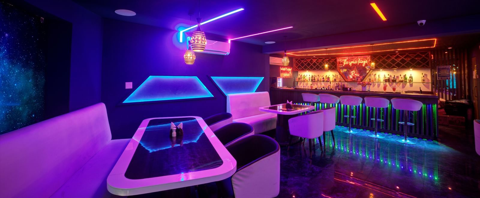 Wide shot of vibrant nightclub with modern decor and sleek bar at Ilara Hotels & Spa, OMR, Chennai
