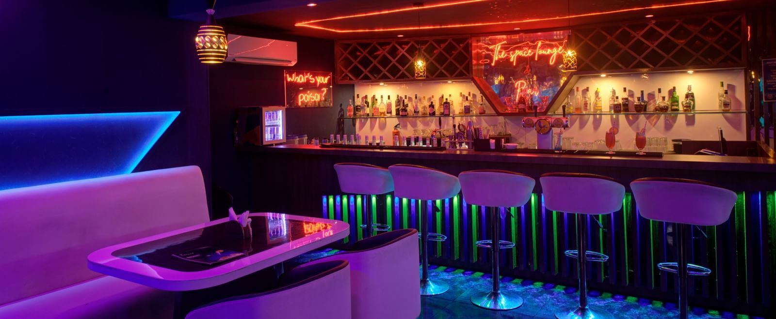 Neon-lit lounge with futuristic booth seating and ambient lighting at Ilara Hotels & Spa, OMR, Chennai