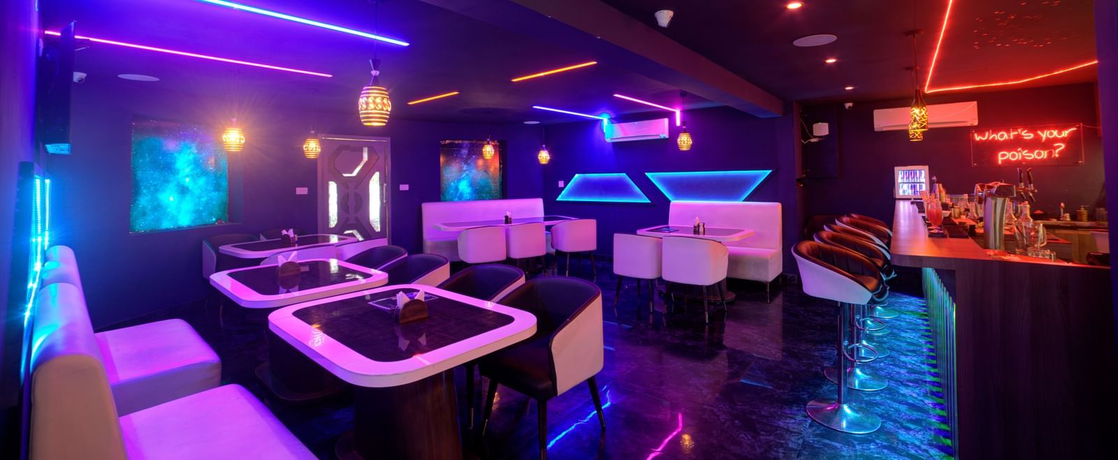 Stylish seating with neon geometric wall lights in lounge bar at Ilara Hotels & Spa, OMR, Chennai