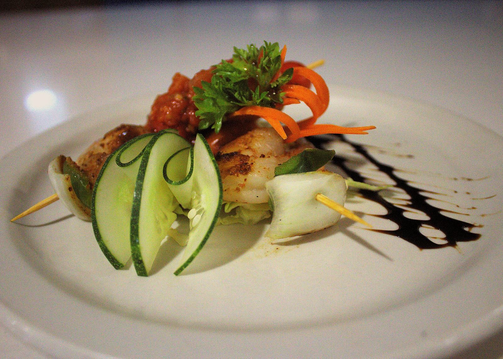 Grilled shrimp on a white plate with sliced cucumber and balsamic glaze - Hotel 39, Jamaica