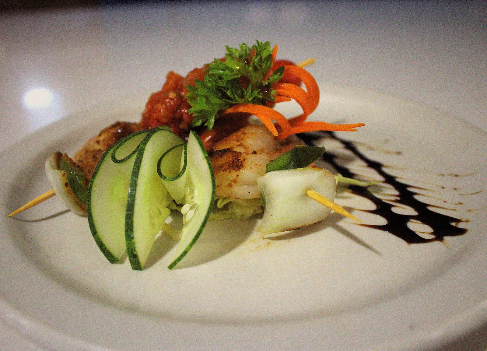 Grilled shrimp on a white plate with sliced cucumber and balsamic glaze - Hotel 39, Jamaica