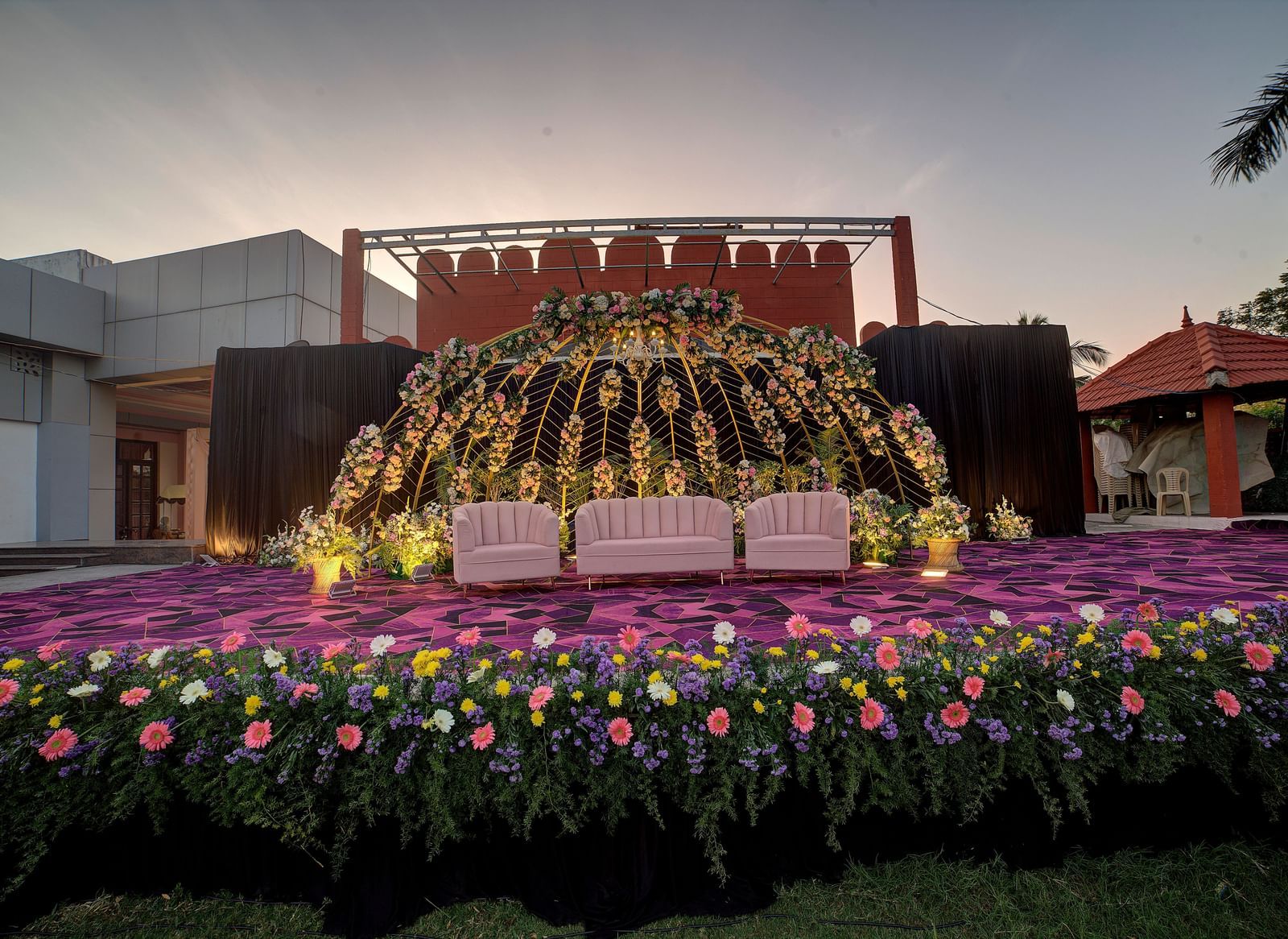 Outdoor stage decorated with vibrant flowers and backdrop for grand celebrations at Kailash Conventions ECR.