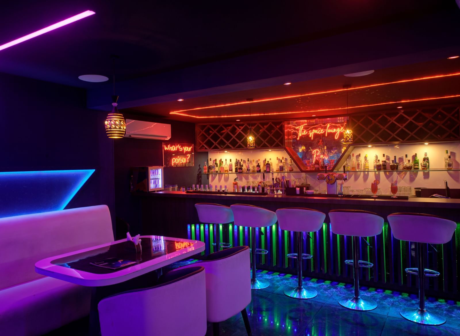 Neon-lit lounge with futuristic booth seating and ambient lighting at Ilara Hotels & Spa, OMR, Chennai