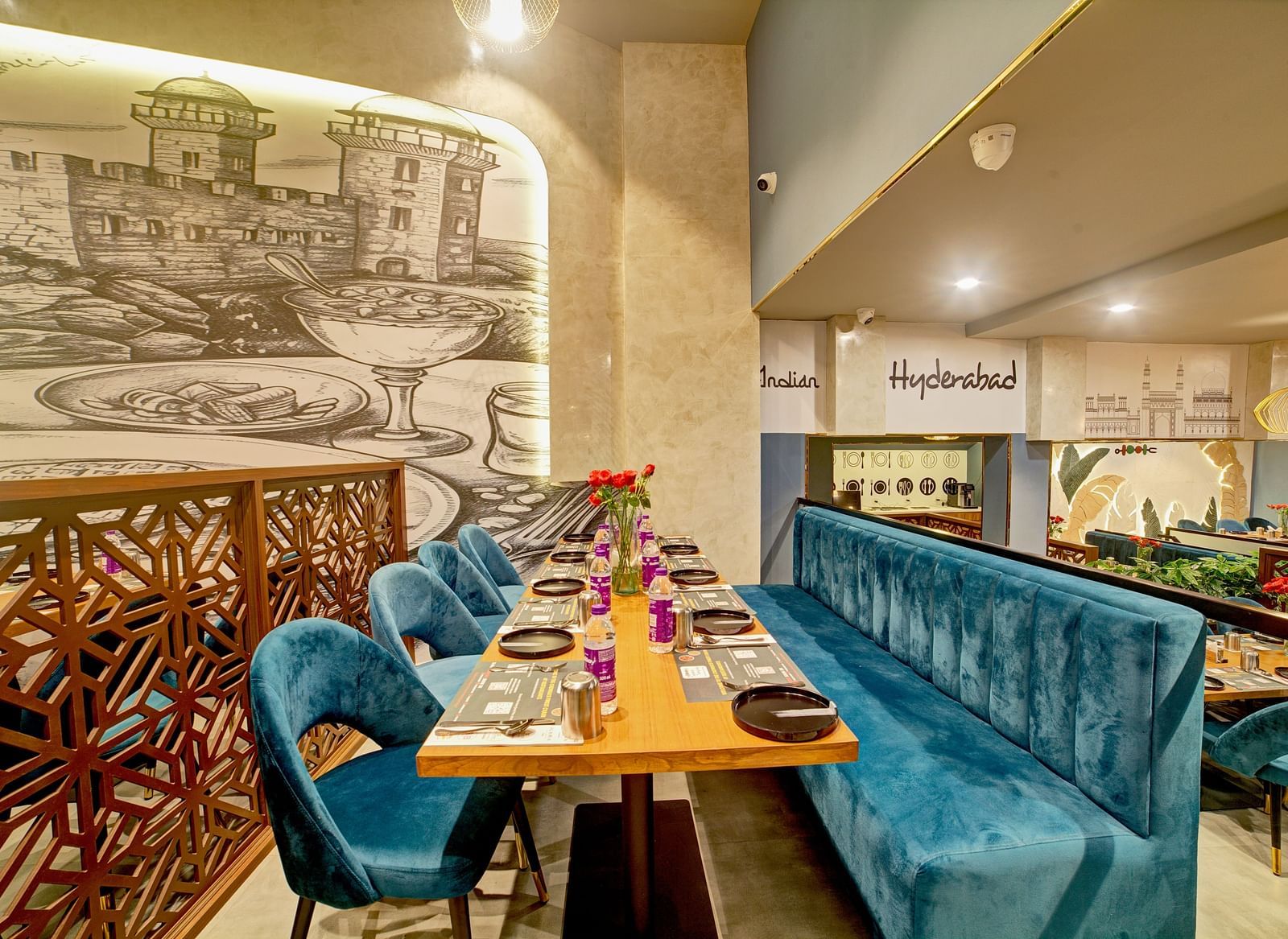 Cosy corner booth with ornate partition and wall illustrations at Ilara Hotels & Spa, OMR, Chennai