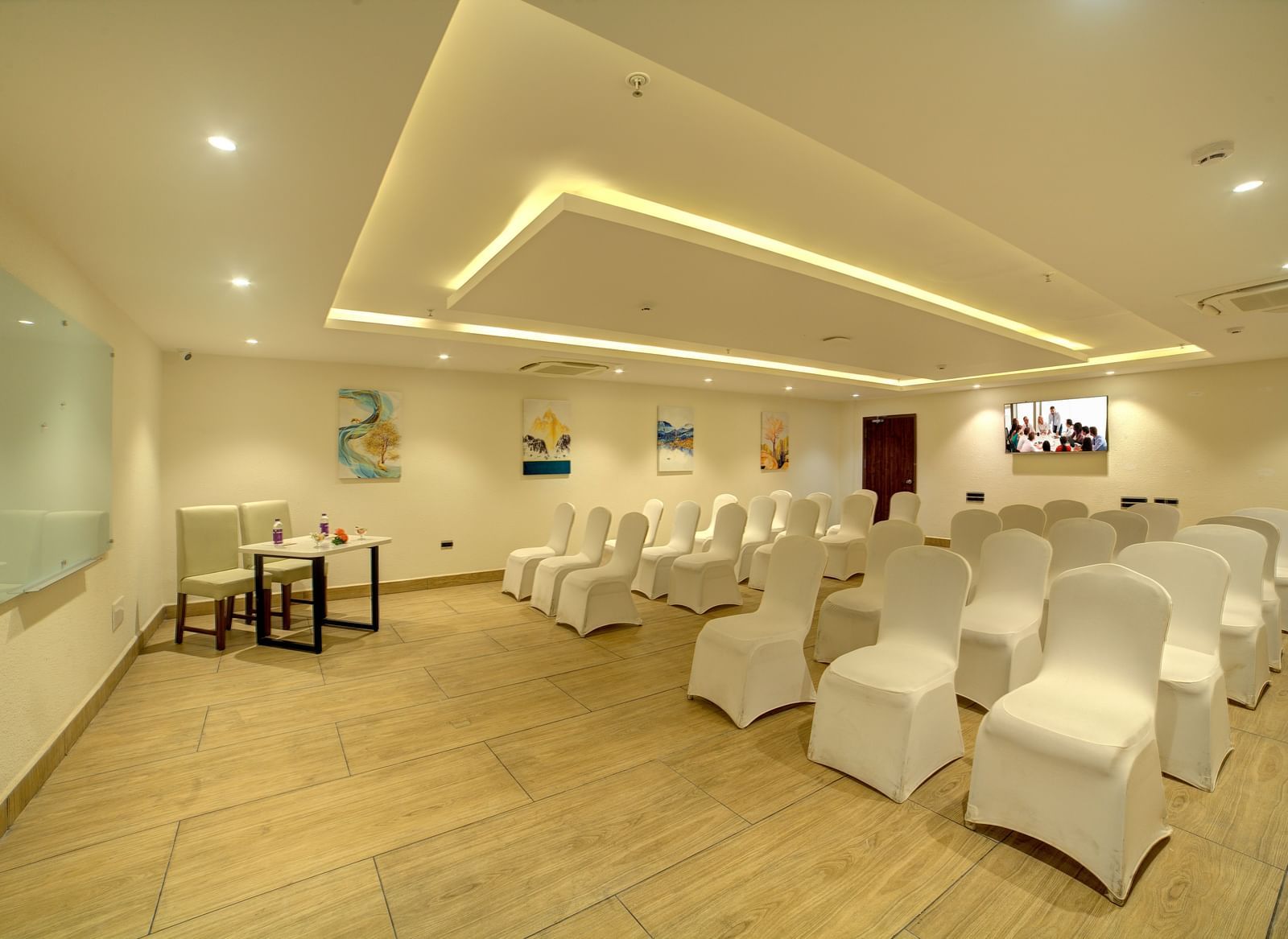 A banquet hall with chairs arranged in three in a row facing towards the projector at Ilara Hotels & Spa, Tada.