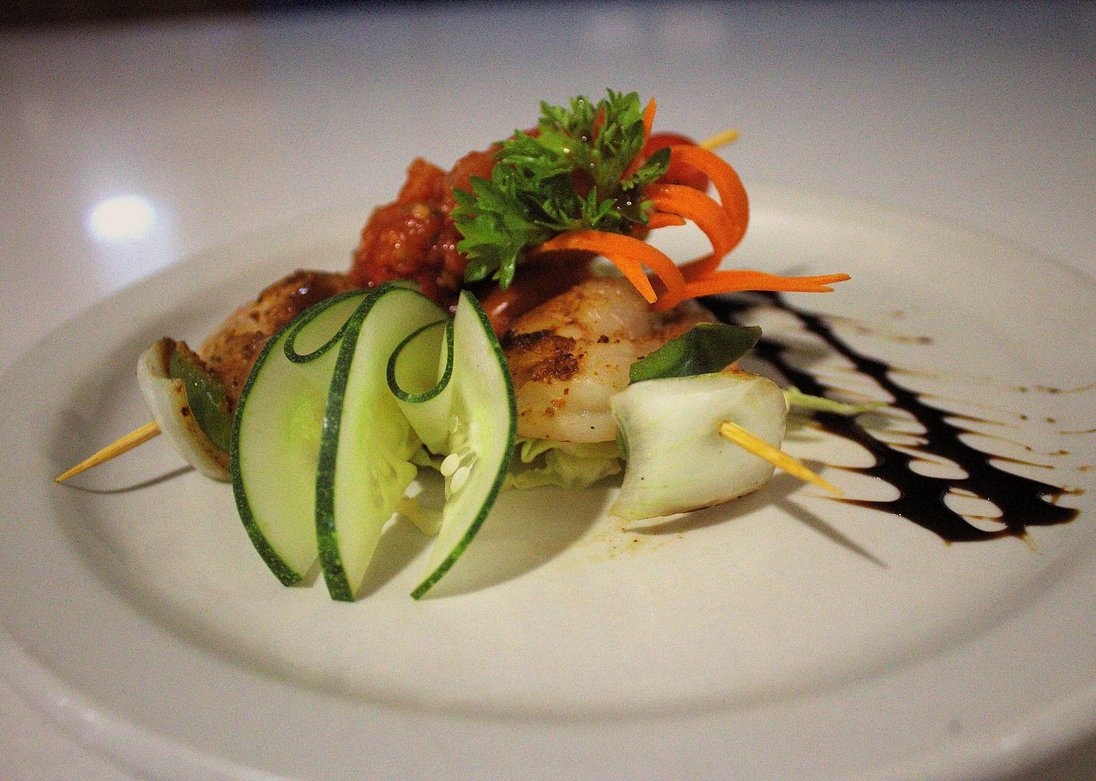 Grilled shrimp on a white plate with sliced cucumber and balsamic glaze - Hotel 39, Jamaica