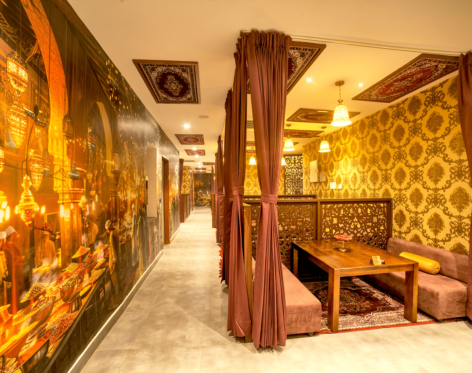 Themed restaurant with golden lighting, plush seating, and ornate décor elements at Ilara Hotels & Spa, OMR, Chennai