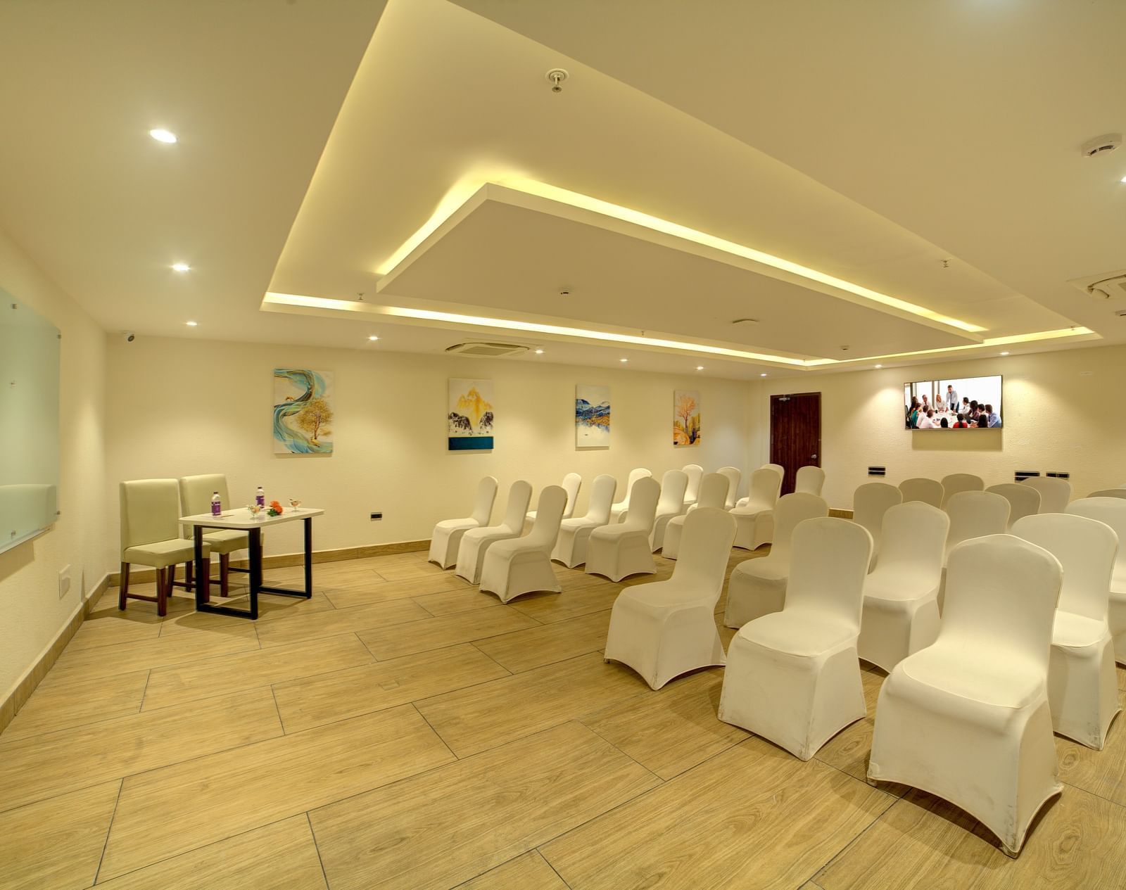 A banquet hall with chairs arranged in three in a row facing towards the projector at Ilara Hotels & Spa, Tada.