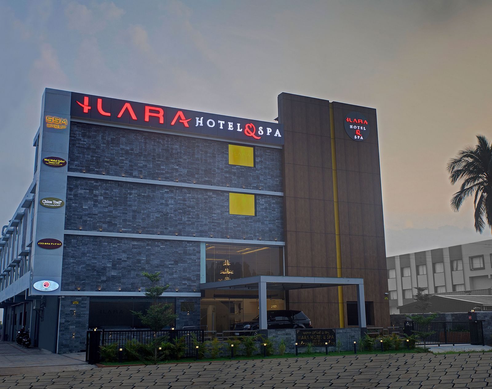 Facade of Ilara Hotels & Spa, Tada with a drive way in the foreground during the late evening hours.