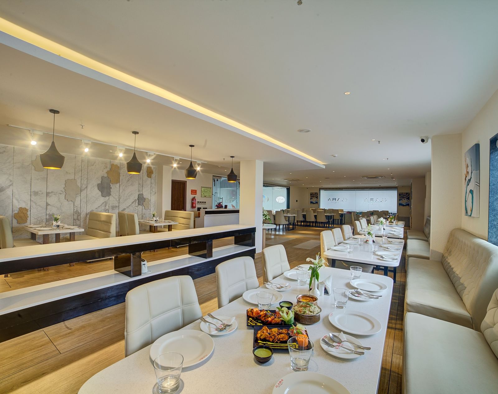  A modern, brightly-lit bar and lounge area with high stools, a sleek counter, and ambient lighting at Ilara Hotels & Spa.