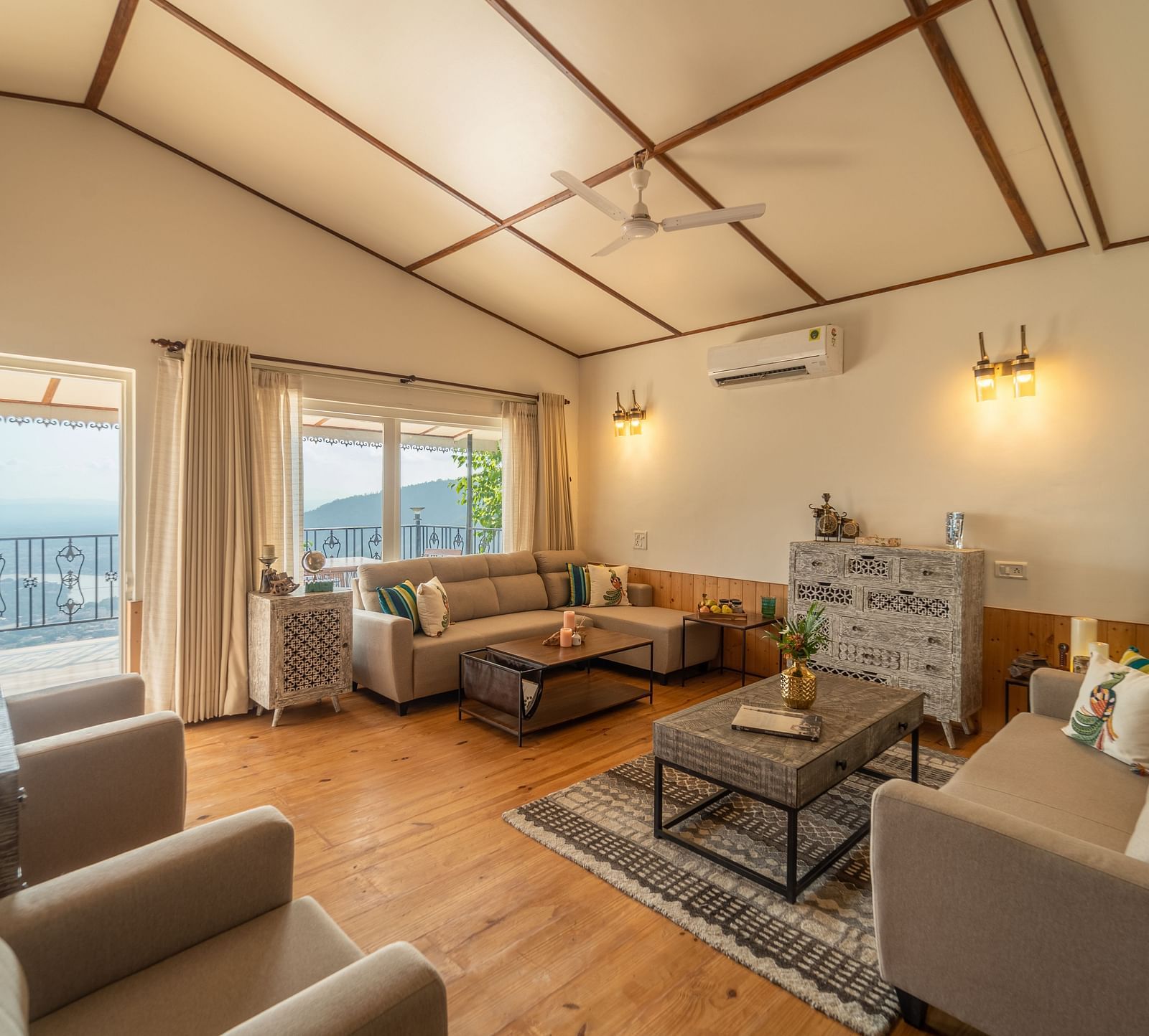 an overview of a living room with sofas and coffee tables inside one of the rooms - neer ganga Resorts