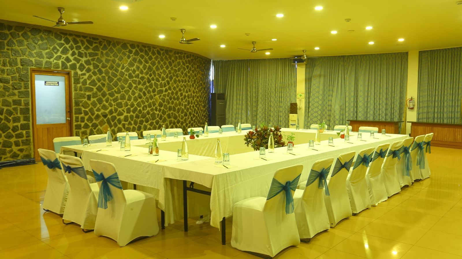 An image of the meeting hall with seating arrangement, bright lighting, and the amenities required for meetings - Great Trails Yercaud by GRT Hotels