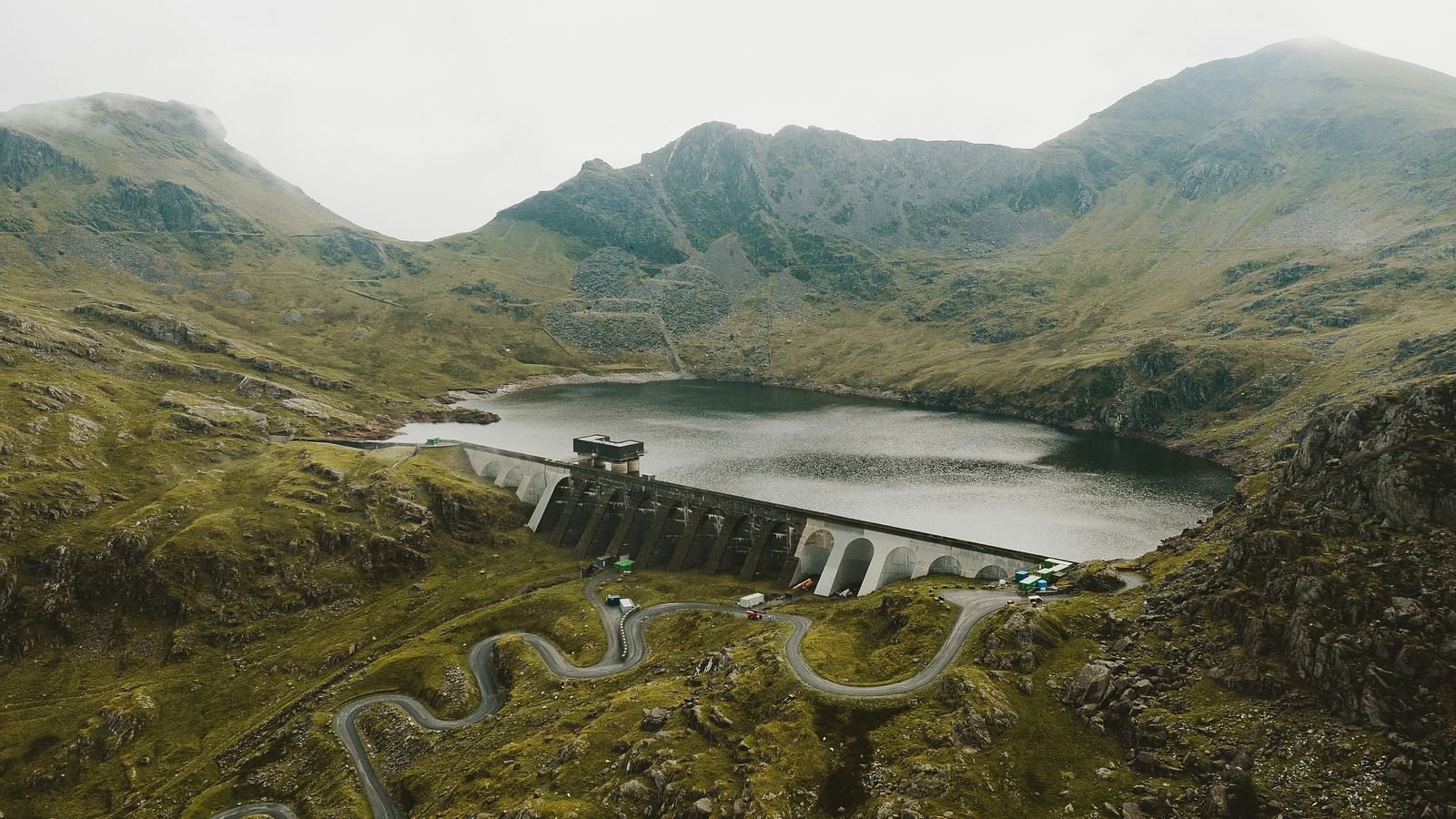 Scenic view of a dam nestled between rolling green hills.