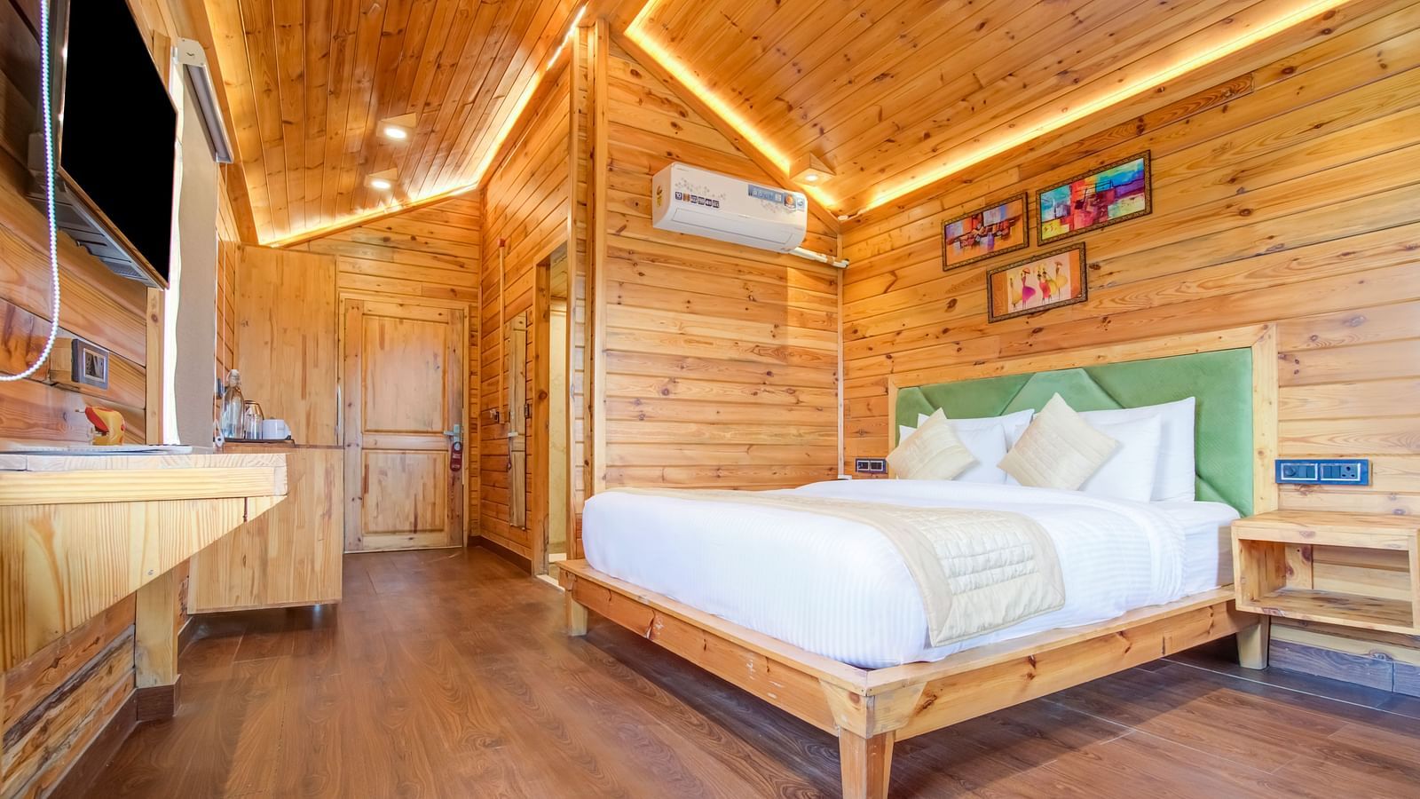 An image of a wooden room with flat TV screen and a bedside table An image of a bedroom with balcony - Summit Jungle Resort, Lansdowne