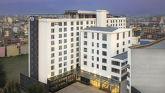 The exterior of Royal Tulip, Kathmandu, a modern, white multi-storey building with many windows at dusk.