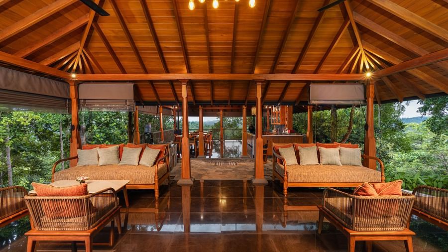  A rustic wooden dining area with large wooden tables and chairs, set in an open pavilion-style structure surrounded by lush greenery - Heavensa Villas and Suites by the Clarks, Galle