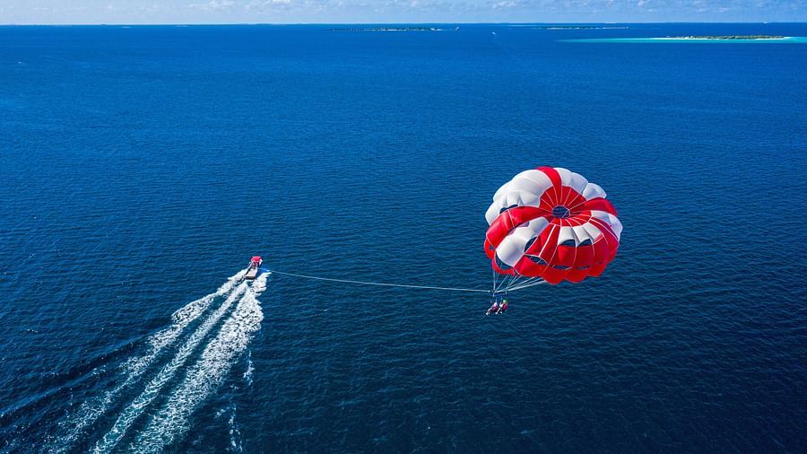 An individual enjoying parasailing with beautiful view of sea in the background