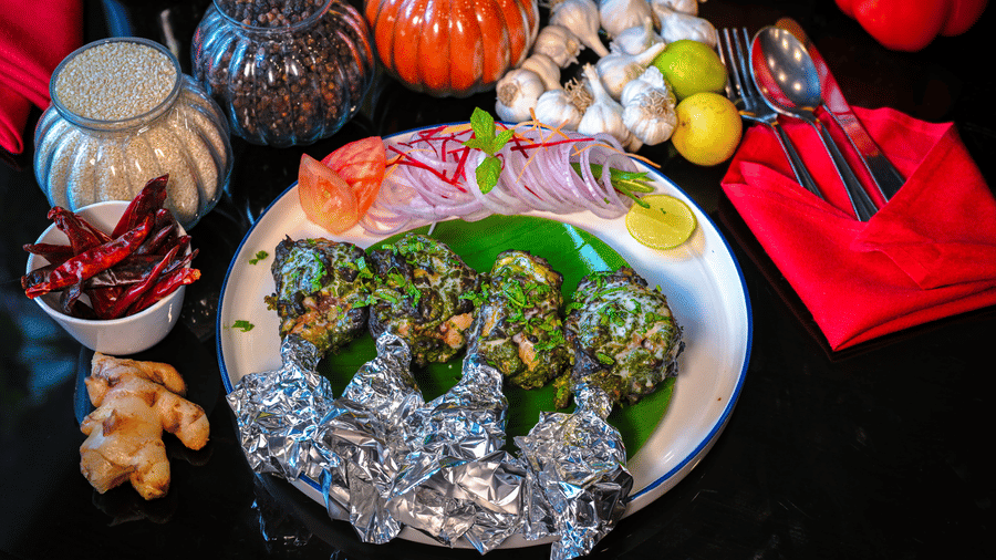 A special dish served on a plate with spice bottles placed in the backdrop for decoration at Clarks Hotels.