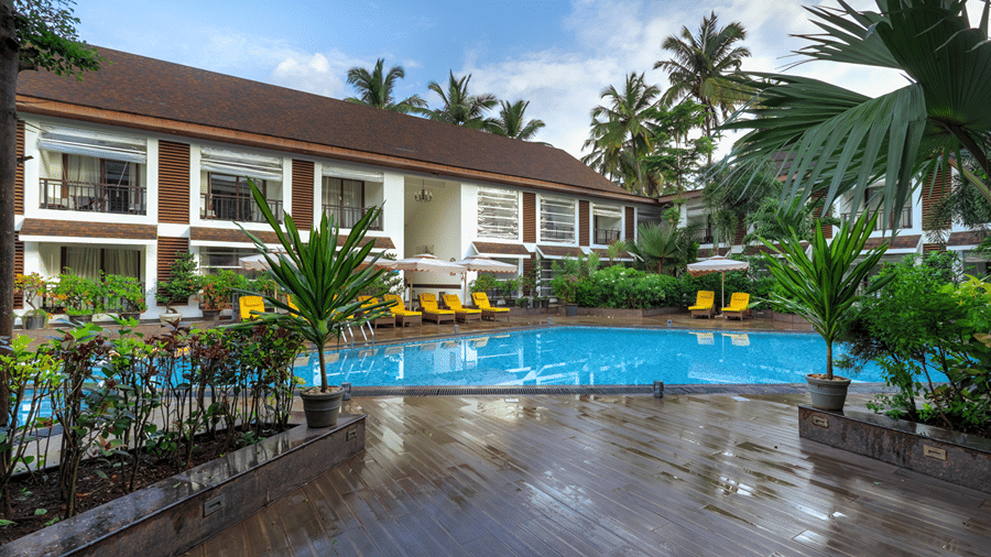 Swimming pool with seating arrangement at Sobit Sarovar Portico, Goa