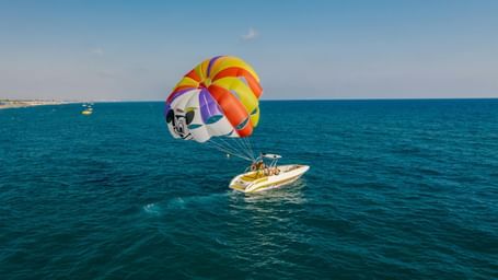 A parachute attached to a boat which is floating on a river.