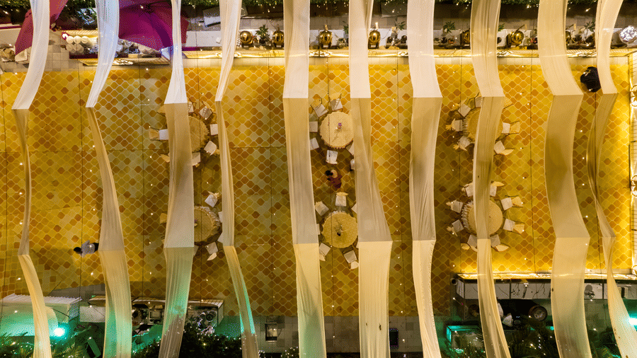 Bird's-eye view of the Gemini Continental outdoor event space, featuring patterned flooring, banquet tables, and long decorative drapes.