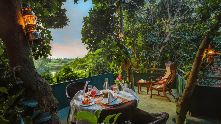 A table for two with numerous items kept on the table for a romantic dining at the Machan, an experience provided Hoysala Vilage Resort, Hassan.