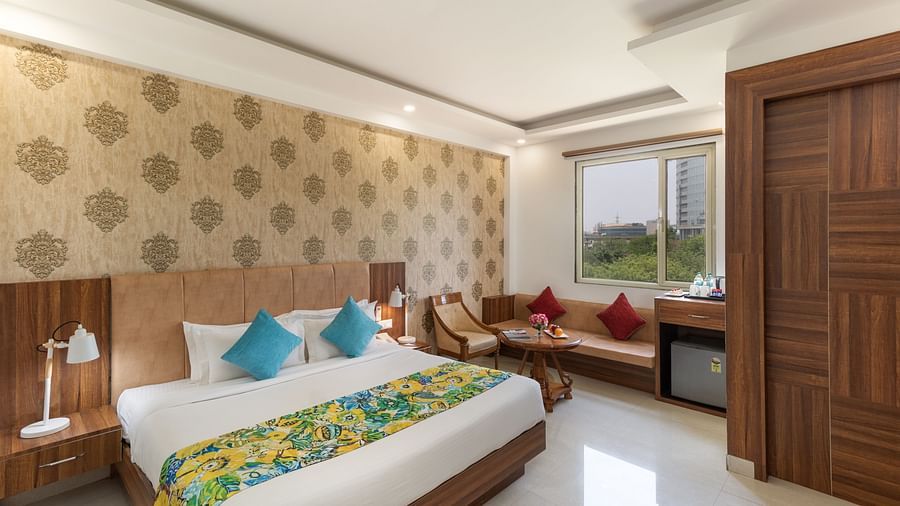 A spacious hotel room featuring a king size bed, comfortable seating, and modern amenities | Inde Hotel Cyber City 