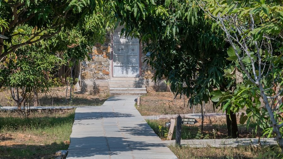 A pathway leading to the rooms with a small signboard mentioning the room name - Utsav Camp