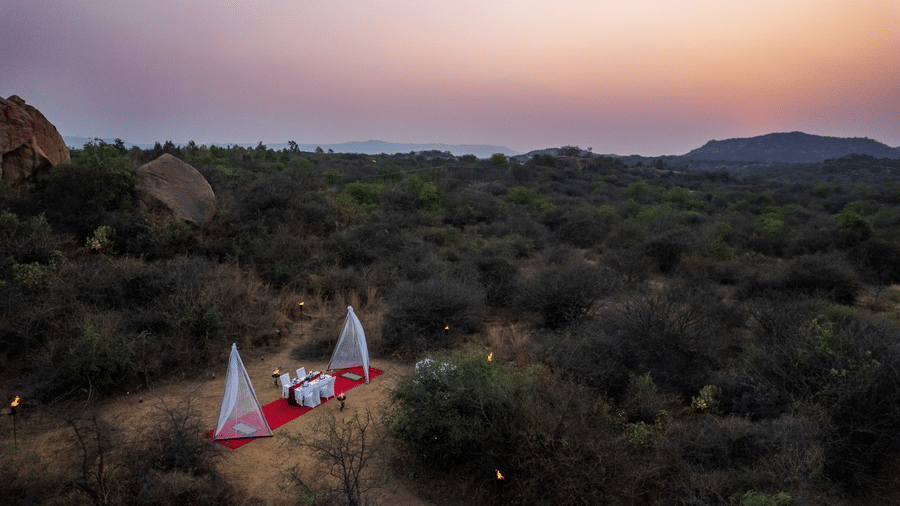 Glamping tents set up in the rocky scrub landscape near Evolve Back Hampi