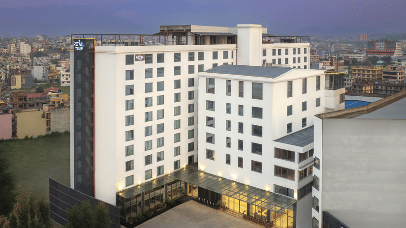 The exterior of Royal Tulip, Kathmandu, a modern, white multi-storey building with many windows at dusk.