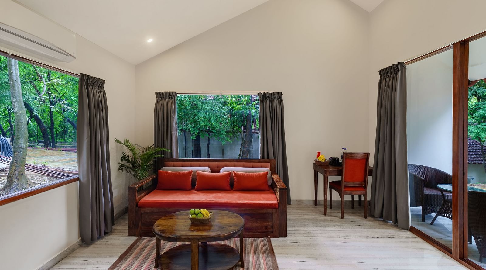 full view of the living room featuring an orange couch with a round coffee table at the luxury suite villa at aranya vilas