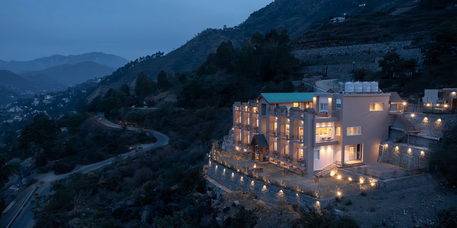 an image of a long shot view of Mountoria Retreat, Naukuchiatal illuminating yellow lights