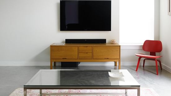 a room with wooden furniture and a TV table and an LCD TV on the wall