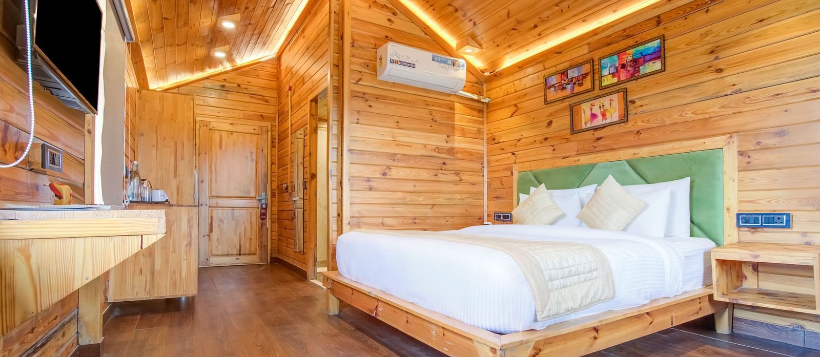 An image of a wooden room with flat TV screen and a bedside table An image of a bedroom with balcony - Summit Jungle Resort, Lansdowne