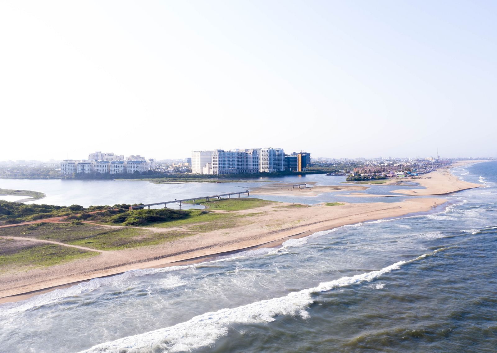 An overview of a beach in chennai with buildings in the distance.
