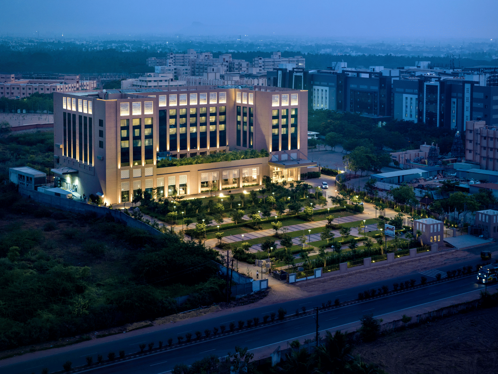 An aerial shot of the grand hotel, highlighting its extensive gardens and well-lit exterior - Grand Madurai by GRT Hotels
