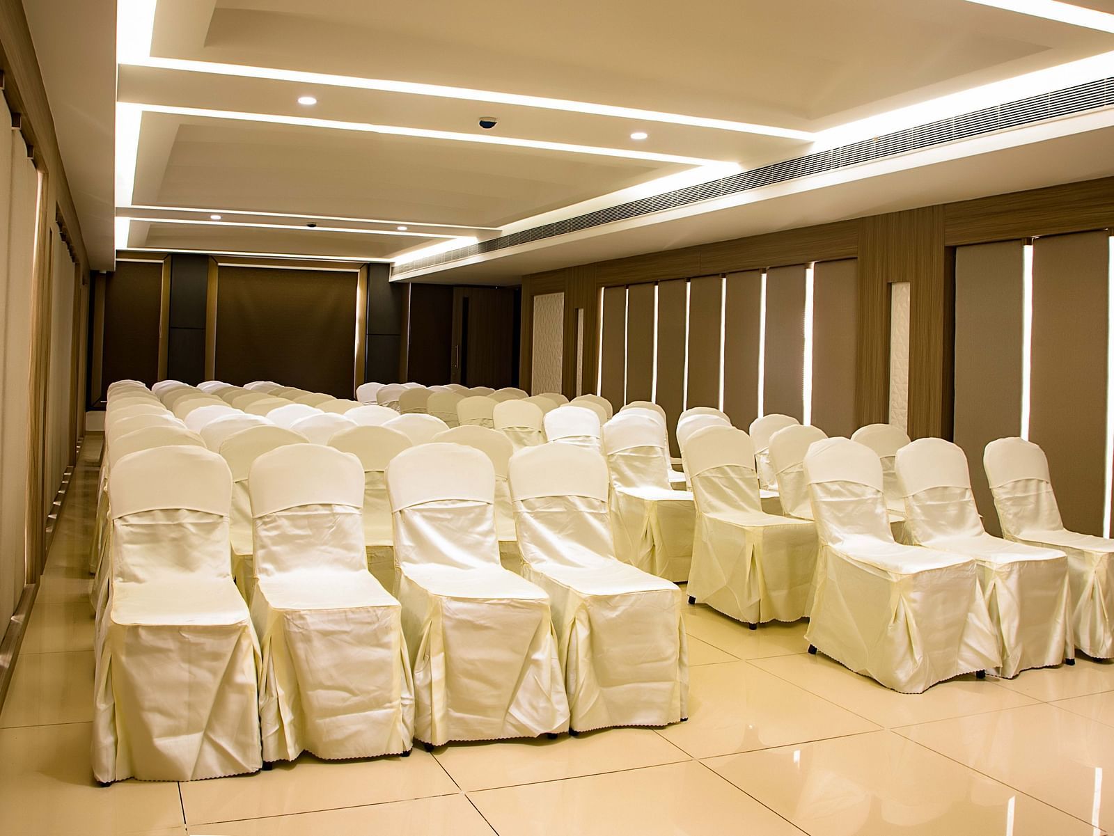 view of event hall with white chairs and warm lights of The Mayberry, Tiruppur