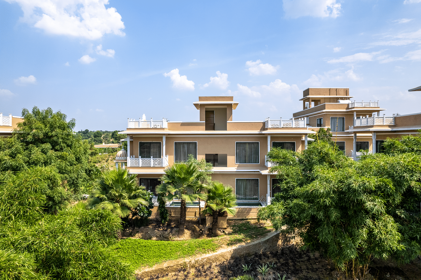 A luxurious building at our wellness centre set against a backdrop of open landscapes - Rajbagh Wellness, Udaipur