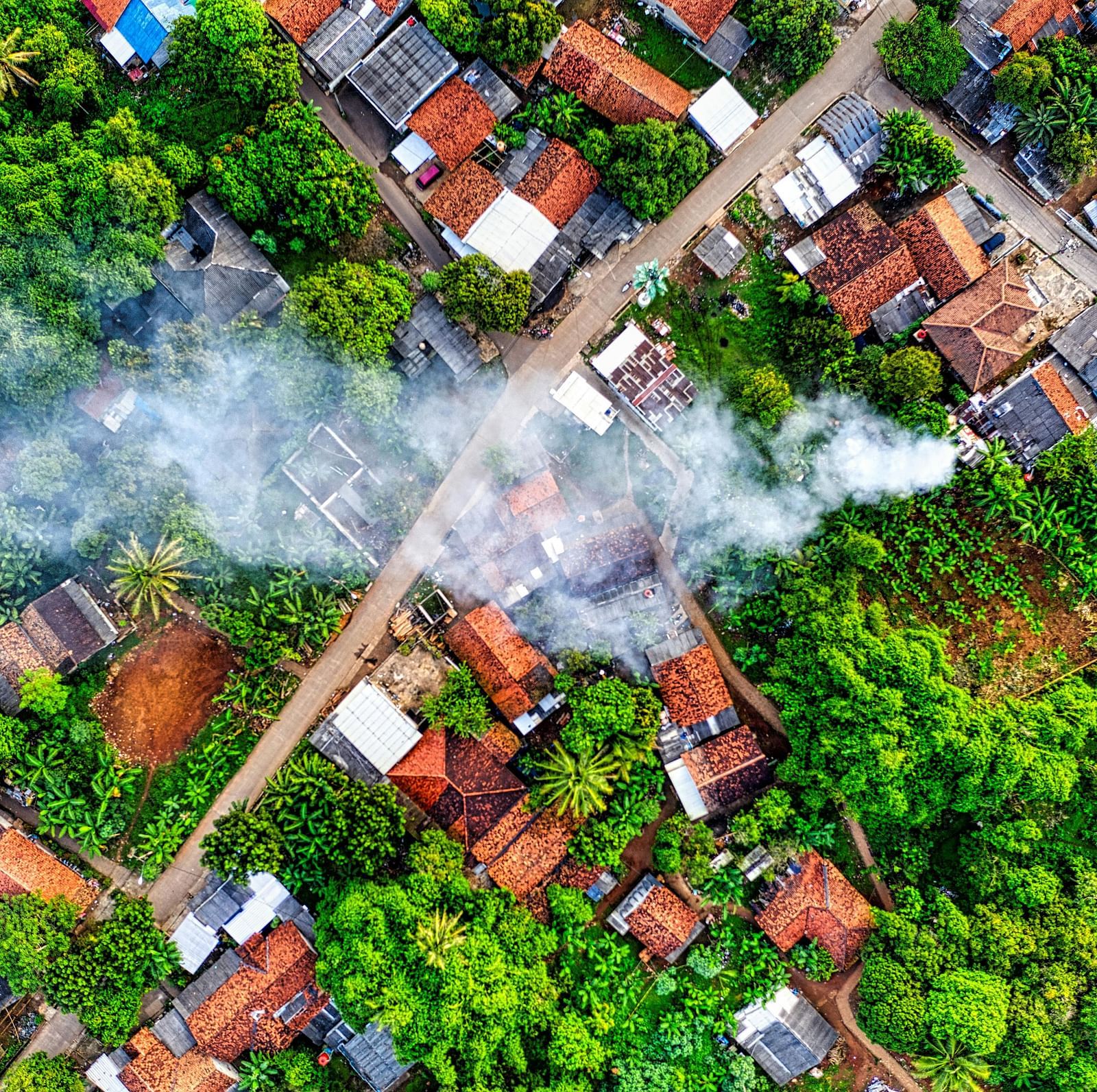 Aerial photo of a village with smoke rising from a central area.
