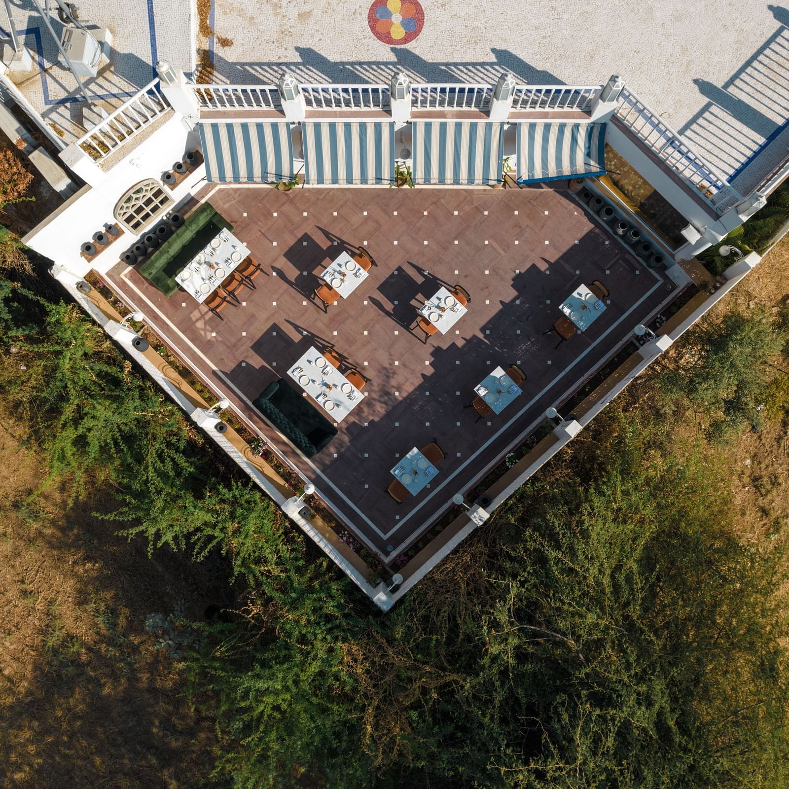 Aerial view of an outdoor dining area with tables and chairs at Surpura Bagh.