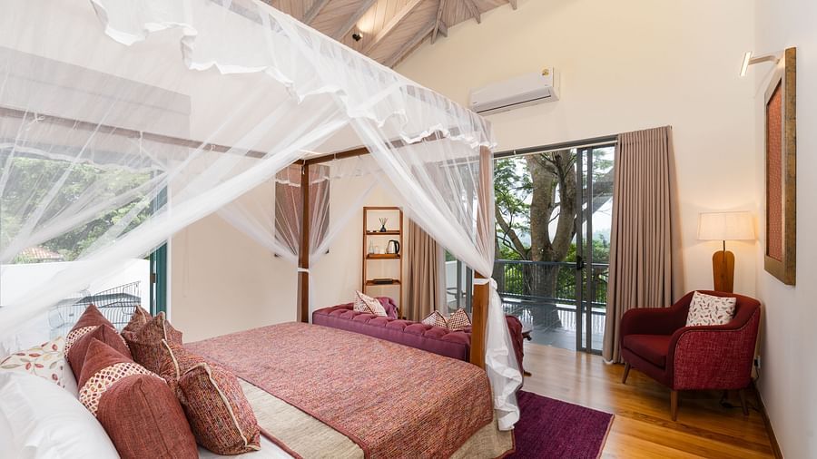 A well-appointed suite with a wooden canopy bed, plush bedding, and modern furniture in warm tones - Executive Suite at Heavensa Villas and Suites by the Clarks, Galle