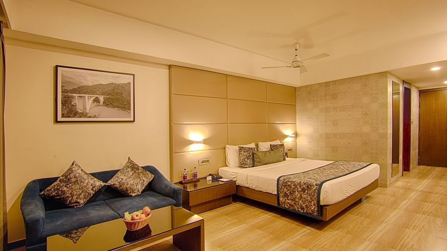 Stylish room with a bed, soft lighting, and a cosy seating area at Voyage Milestone Hotel and Banquet Siliguri