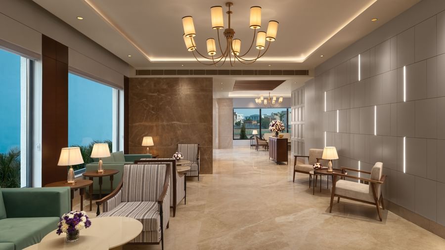 A hotel lounge at Sarovar Portico, Hanumangarh, with sofas, armchairs, and tables.
