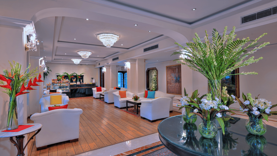 A lounge with sofas, plants, and lights at Clarks Varanasi.
