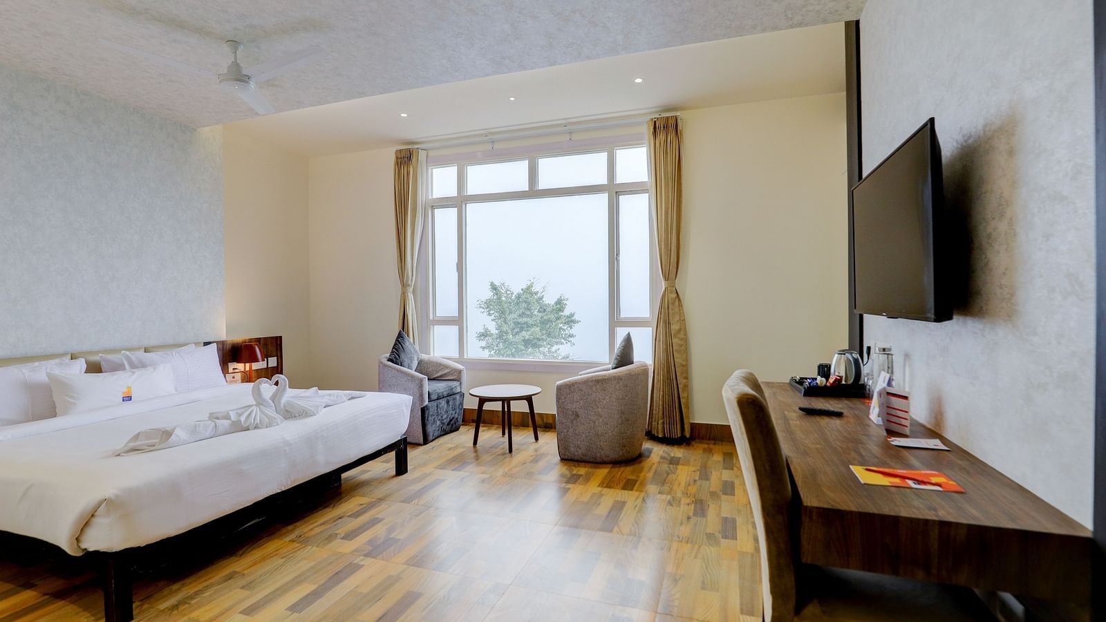 view of a TV and a  king size bed placed next to a window Suite at Banari Regency by Summit, Namchi