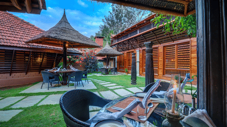 Outdoor restaurant amidst the beautiful garden at the hoysala village resort in hassan