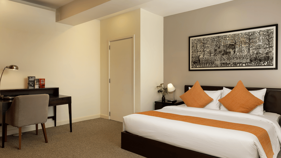 Penthouse bedroom at Central Mansions, Phnom Penh featuring a king bed, work desk, and spacious interiors.