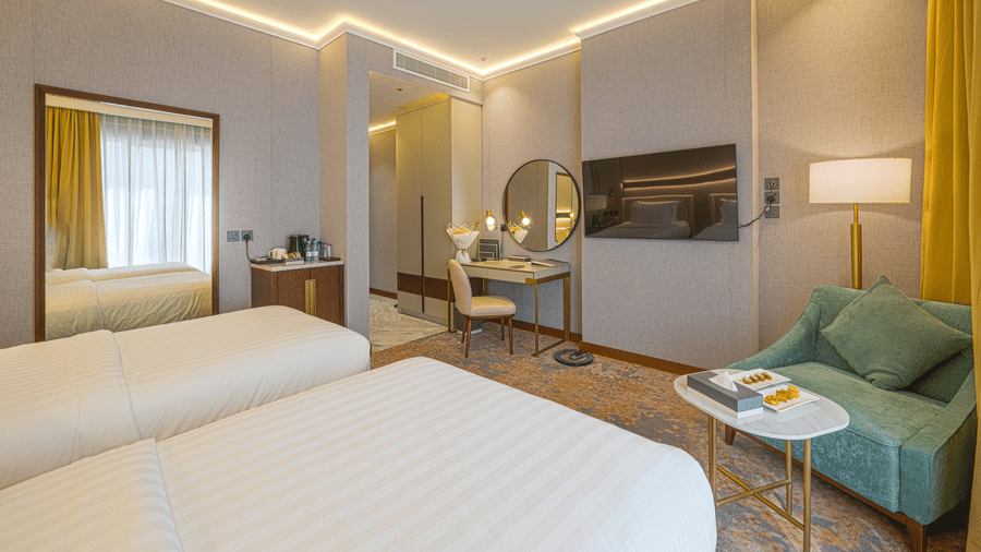 Standard Twin Rooms at Grand Iva Hotel, Abha, with the twin beds facing the wall-mounted TV, work desk, and seating area.