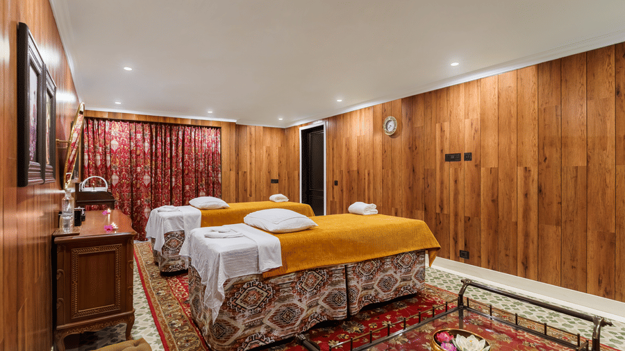 Warmly lit massage therapy suite with wooden panelling at Mayfair Manor, Jungpana.