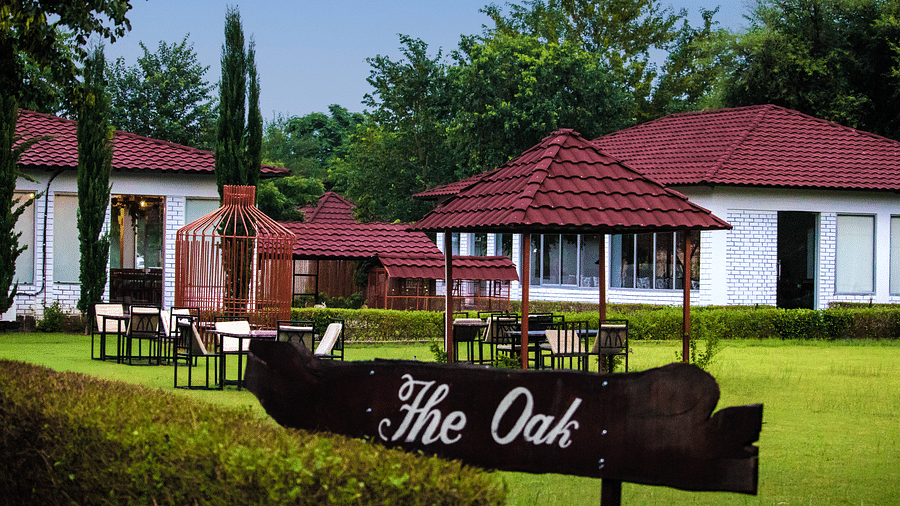 A signboard that reads the oak with accommodations in the background at Valley by Grassfield.